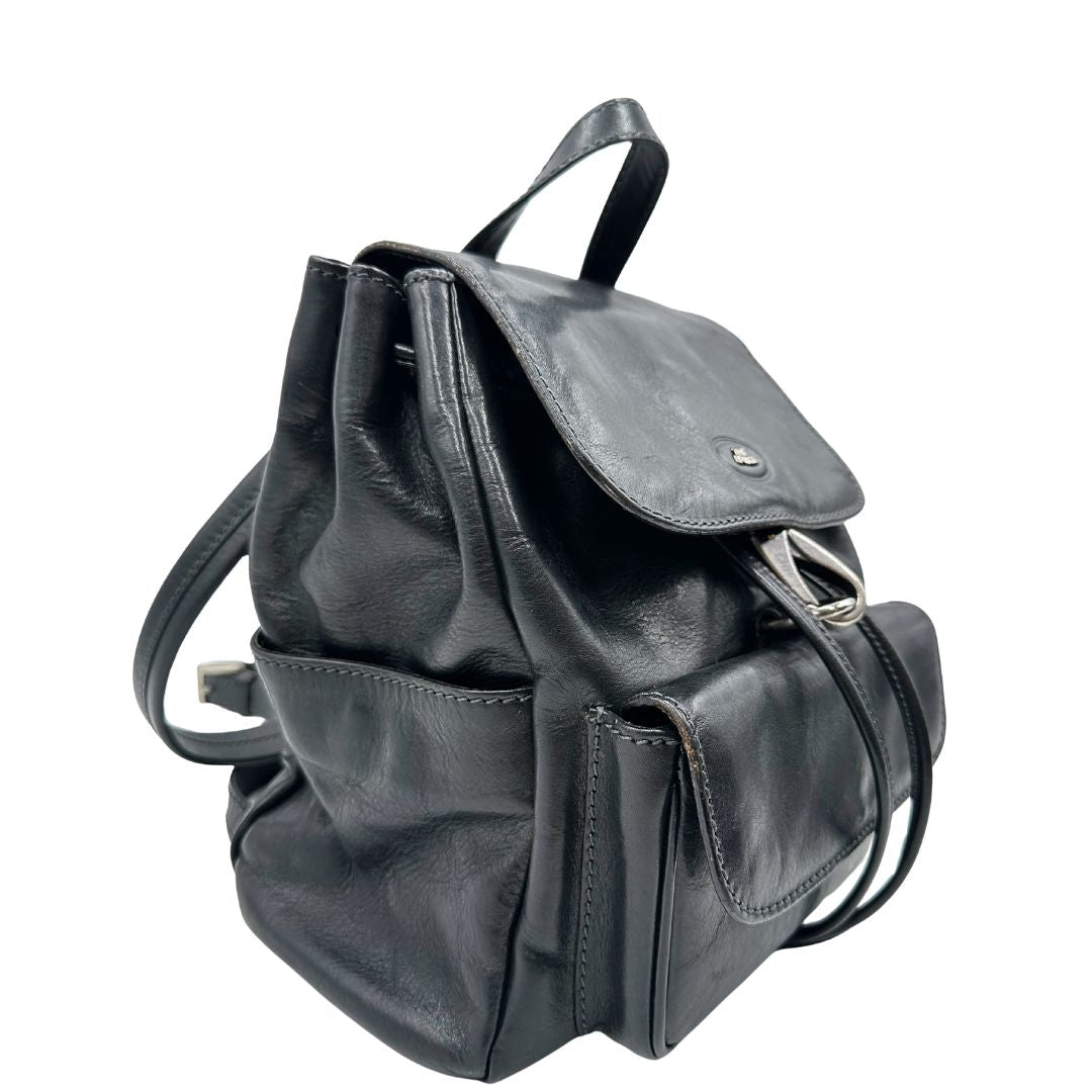 Laterale sinistro di uno zaino The Bridge in cuoio nero con parti metalliche argentate. Cinghie delle bretelle regolabili. Completo di dustbag.