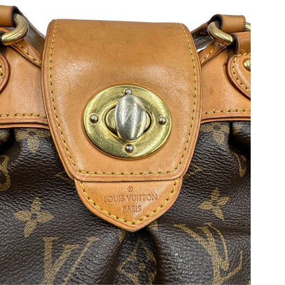 Chiusura di una borsa Louis Vuitton in canvas marrone monogram con finiture in vacchetta naturale e parti metalliche dorate; munita di doppi manici stondati, da indossare a mano.