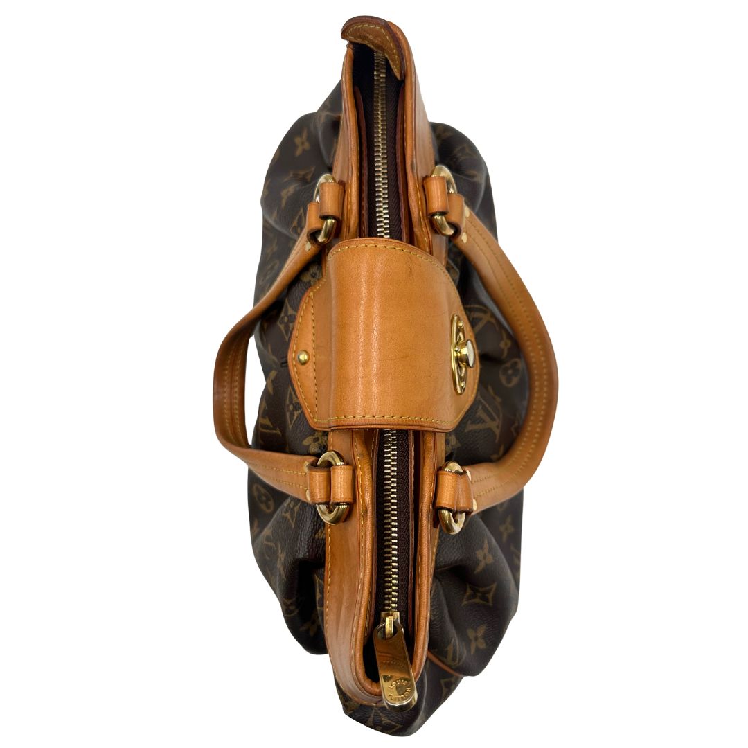 Vista dall'alto di una borsa Louis Vuitton in canvas marrone monogram con finiture in vacchetta naturale e parti metalliche dorate; munita di doppi manici stondati, da indossare a mano.