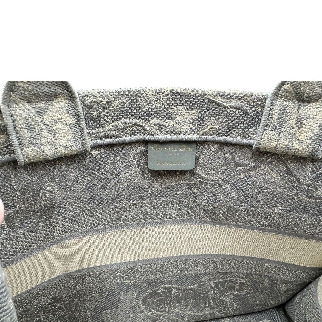 Interno di una borsa tote CD in tessuto grigio e écru con ricamo Toile De Jouy. Da indossare a mano. Completa di dustbag.