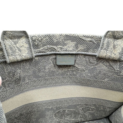 Interno di una borsa tote CD in tessuto grigio e écru con ricamo Toile De Jouy. Da indossare a mano. Completa di dustbag.