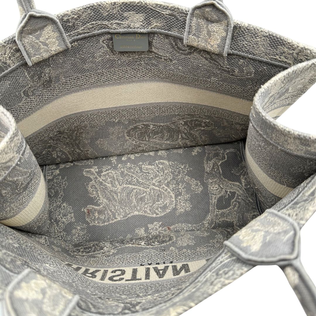 Interno di una borsa tote CD in tessuto grigio e écru con ricamo Toile De Jouy. Da indossare a mano. Completa di dustbag.
