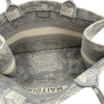 Interno di una borsa tote CD in tessuto grigio e écru con ricamo Toile De Jouy. Da indossare a mano. Completa di dustbag.