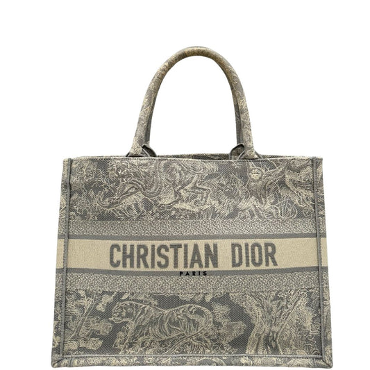 Front di una borsa tote CD in tessuto grigio e écru con ricamo Toile De Jouy. Da indossare a mano. Completa di dustbag.