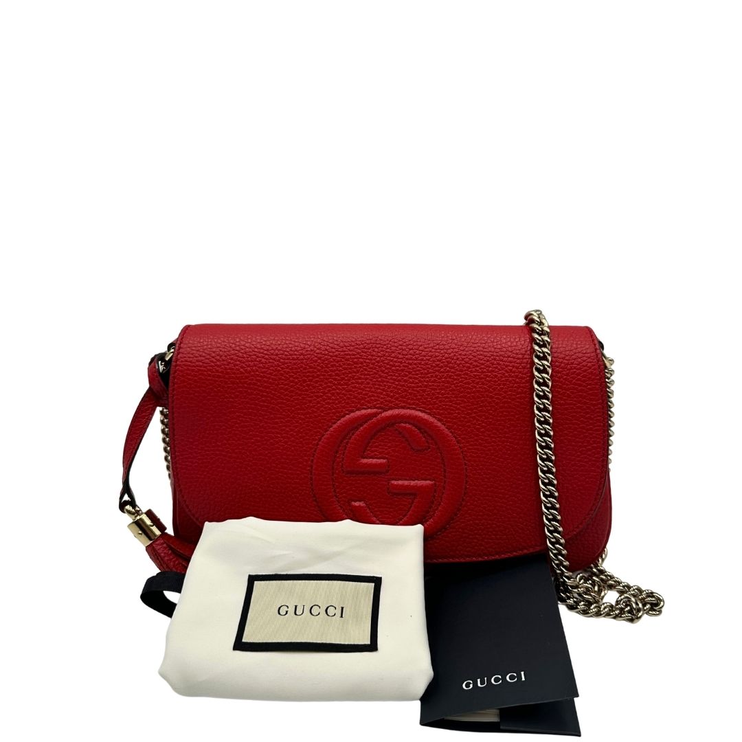 Borsa Gucci in pelle martellata rossa con parti metalliche oro chiaro; impreziosita da nappa e munita di una tracolla in catena. Completa di dustbag, di lusso, originale, ottime condizioni. 