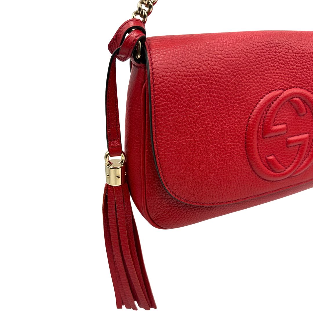 lato Borsa Gucci in pelle martellata rossa con parti metalliche oro chiaro; impreziosita da nappa e munita di una tracolla in catena. Completa di dustbag, di lusso, originale, ottime condizioni. 