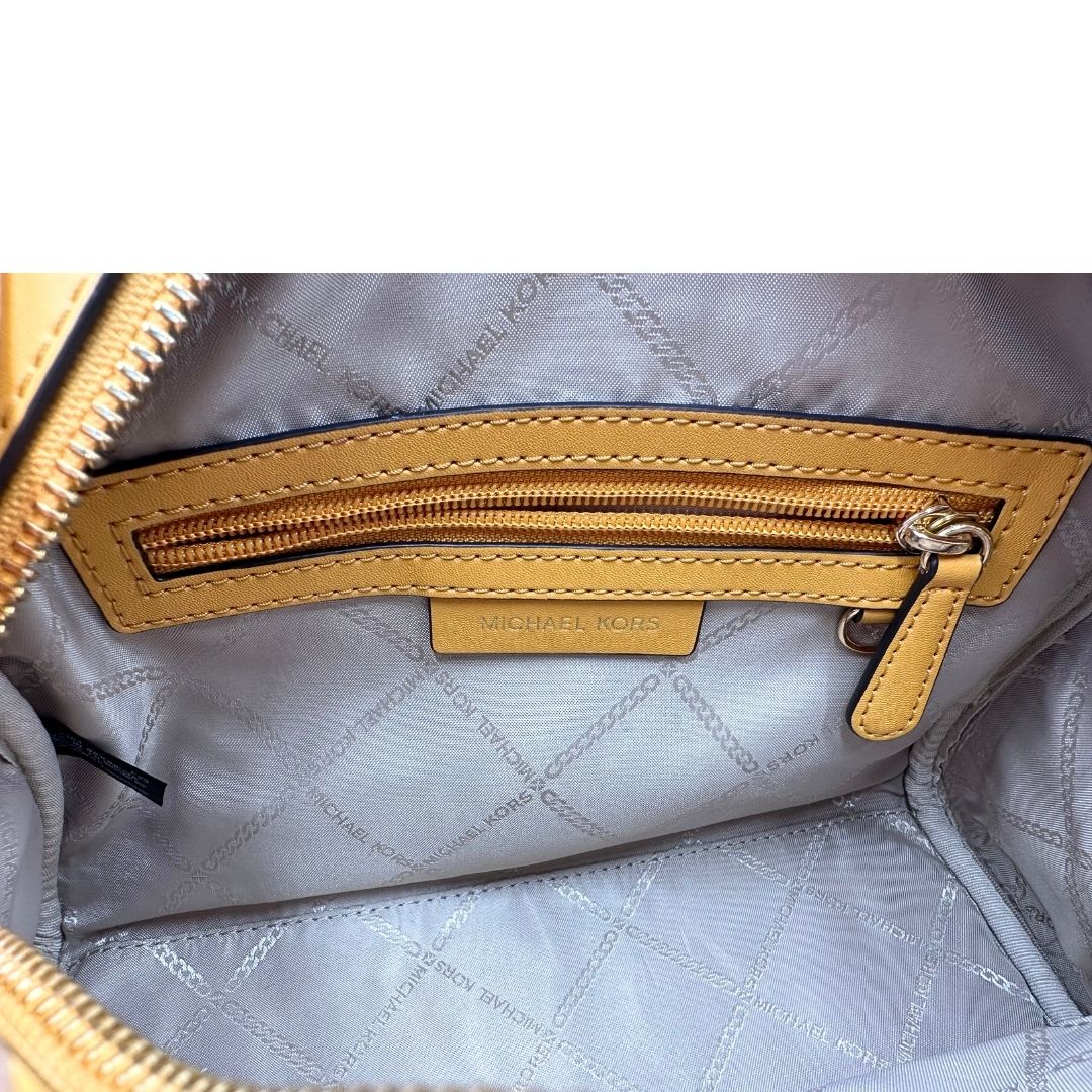 Interno di una borsa Michael Kors in pelle martellata giallo girasole, con metalleria dorata. Munita di tracolla in tessuto regolabile ed amovibile. Completa di dustbag e cartellini.