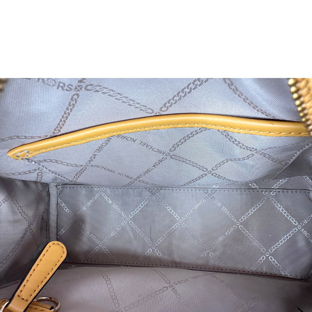 Interno di una borsa Michael Kors in pelle martellata giallo girasole, con metalleria dorata. Munita di tracolla in tessuto regolabile ed amovibile. Completa di dustbag e cartellini.