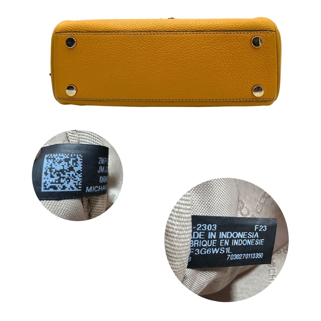 Base e codici di una borsa Michael Kors in pelle martellata giallo girasole, con metalleria dorata. Munita di tracolla in tessuto regolabile ed amovibile. Completa di dustbag e cartellini.