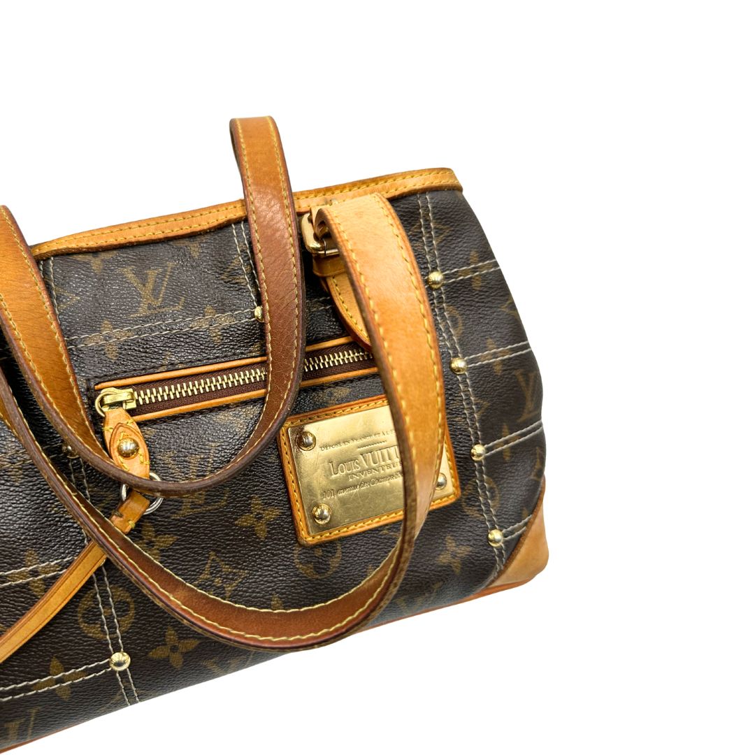 Manici di una Borsa Louis Vuitton in canvas marrone monogram con cuciture decorative e finiture in vacchetta naturale. Parti metalliche dorate; munita di doppi manici, indossabile a spalla. Originale, usata, di lusso in ottime condizioni