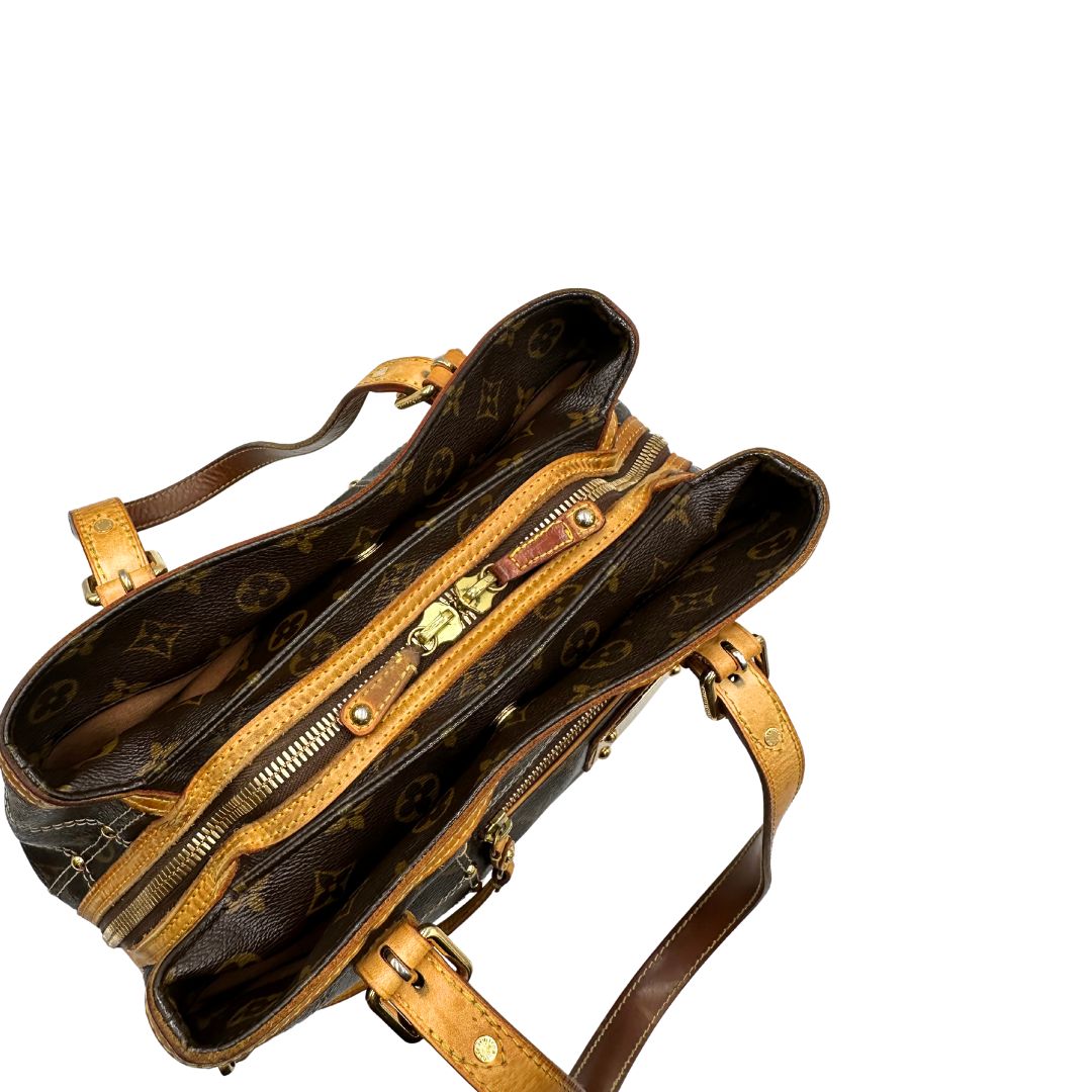 Chiusura di una Borsa Louis Vuitton in canvas marrone monogram con cuciture decorative e finiture in vacchetta naturale. Parti metalliche dorate; munita di doppi manici, indossabile a spalla. Originale, usata, di lusso in ottime condizioni