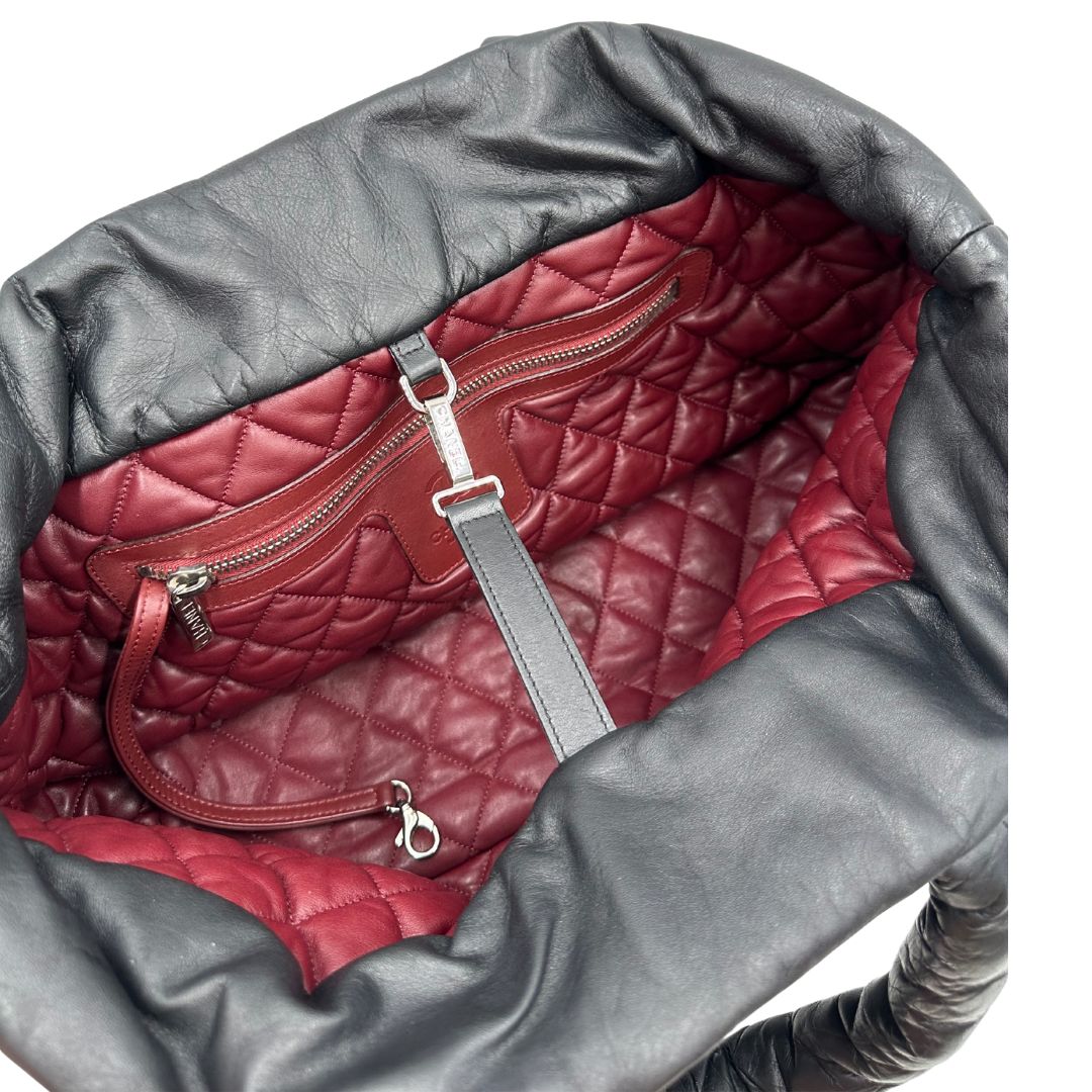 Interno di una borsa Chanel in pelle effetto imbottito nera, con metalleria argentata. Da indossare a spalla.