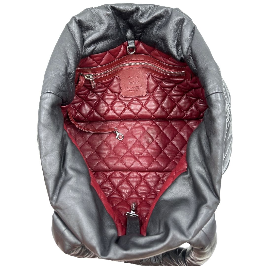 Interno di una borsa Chanel in pelle effetto imbottito nera, con metalleria argentata. Da indossare a spalla.