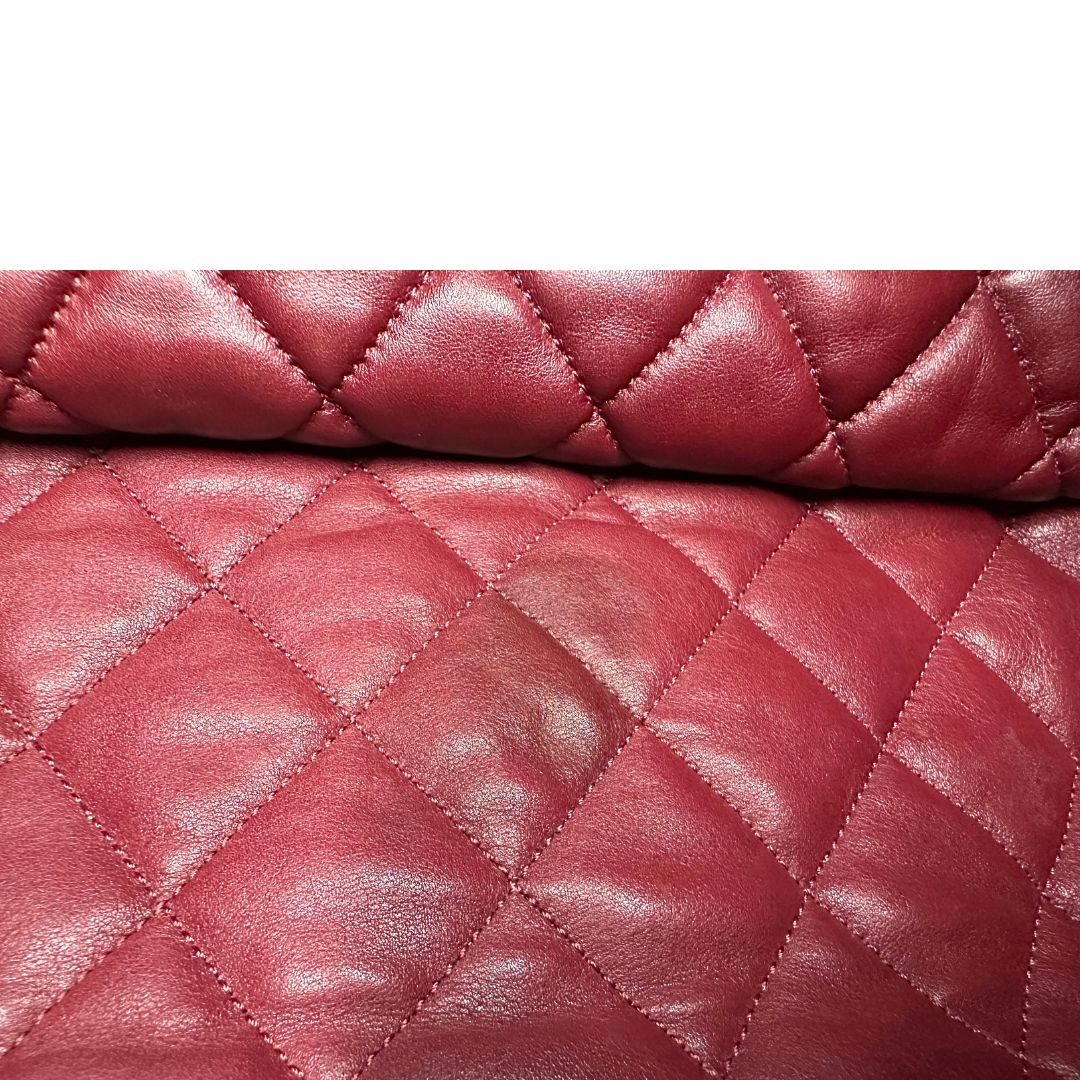 Dettaglio difetto di una borsa Chanel in pelle effetto imbottito nera, con metalleria argentata. Da indossare a spalla.