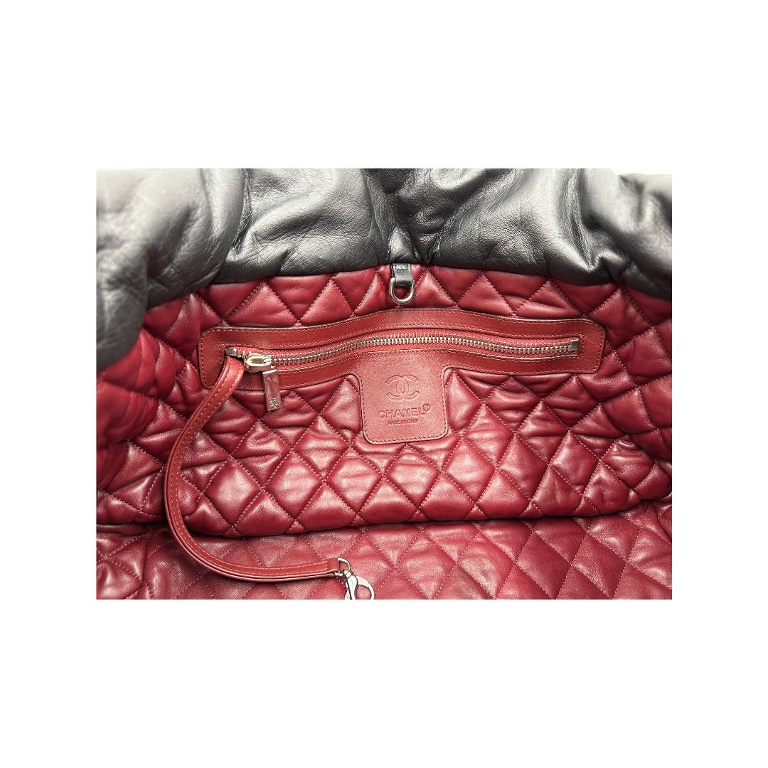 Interno di una borsa Chanel in pelle effetto imbottito nera, con metalleria argentata. Da indossare a spalla.