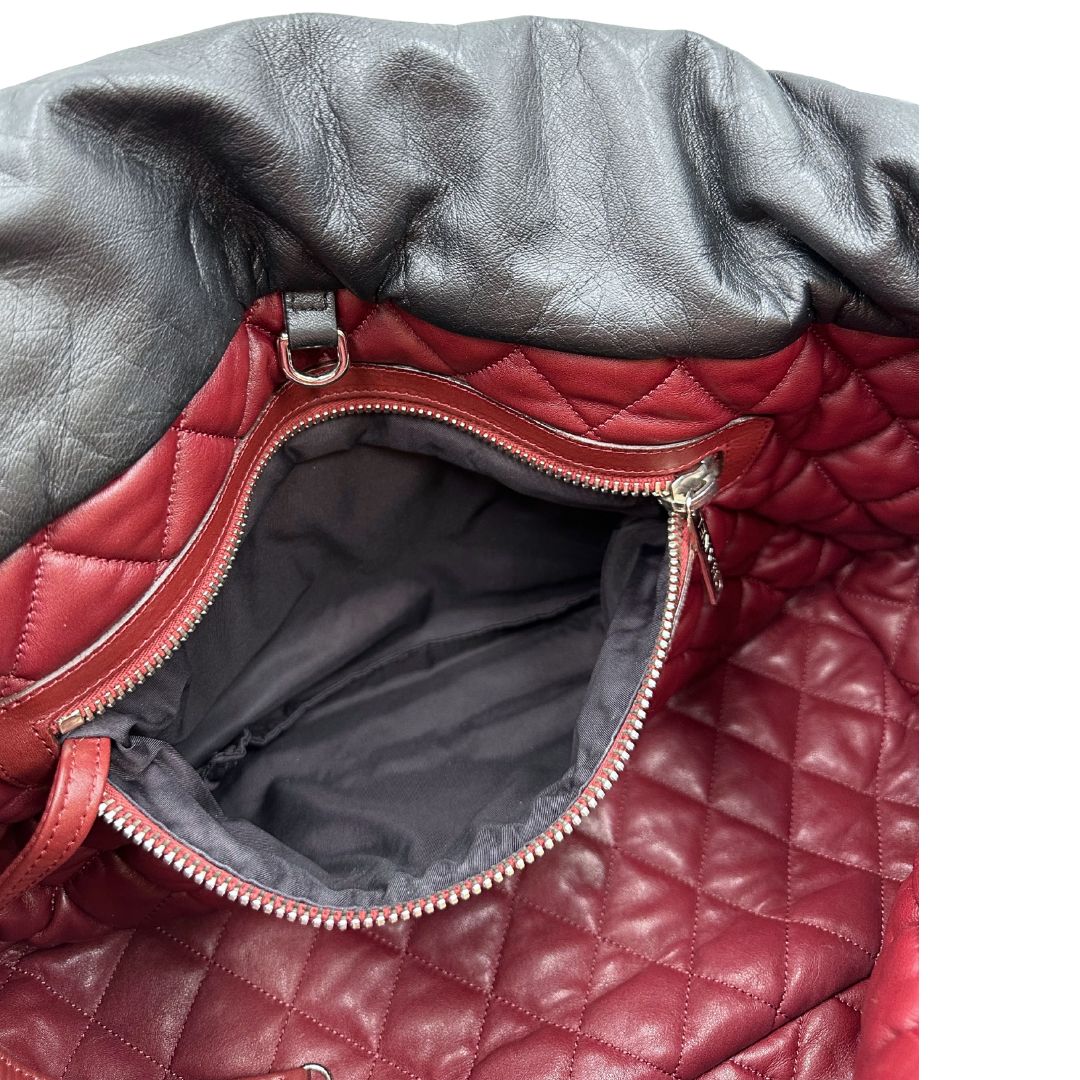 Interno di una borsa Chanel in pelle effetto imbottito nera, con metalleria argentata. Da indossare a spalla.