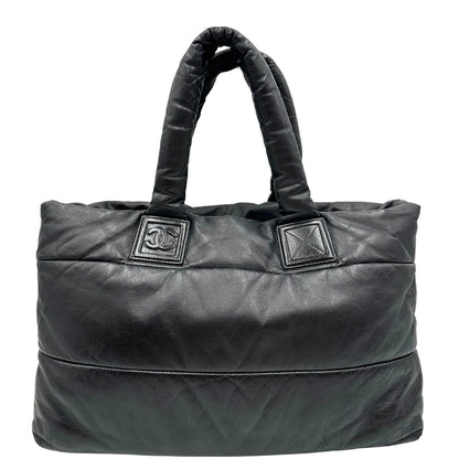 Front di una borsa Chanel in pelle effetto imbottito nera, con metalleria argentata. Da indossare a spalla.