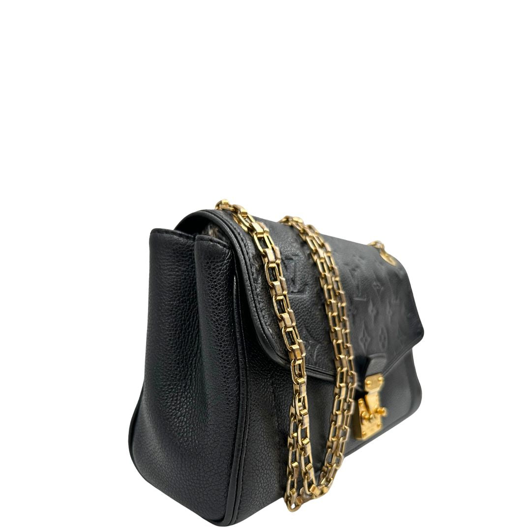 Laterale sinistro di una borsa Louis Vuitton in pelle nera monogram Empreinte con parti metalliche dorate; munita di una tracolla scorrevole in catena. Indossabile a spalla e a tracolla.