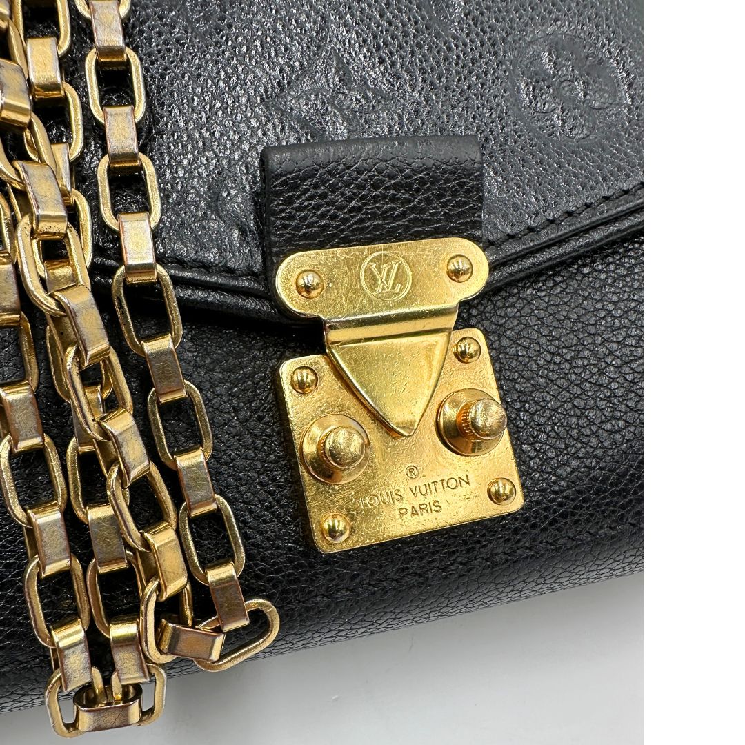 Chiusura di una borsa Louis Vuitton in pelle nera monogram Empreinte con parti metalliche dorate; munita di una tracolla scorrevole in catena. Indossabile a spalla e a tracolla.