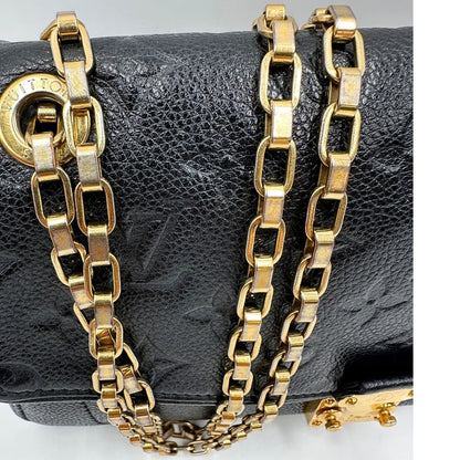 Dettagli catene scolorite di una borsa Louis Vuitton in pelle nera monogram Empreinte con parti metalliche dorate; munita di una tracolla scorrevole in catena. Indossabile a spalla e a tracolla.