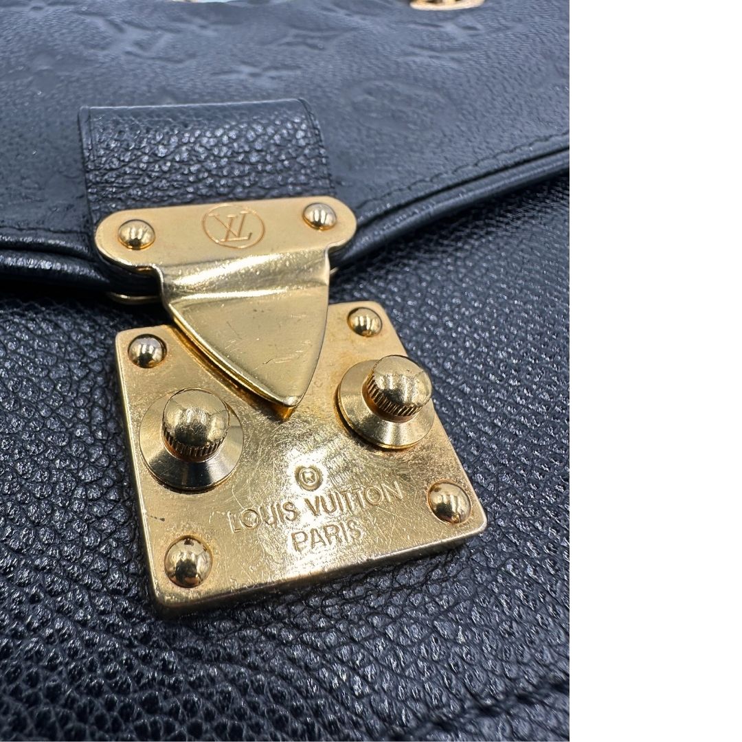 Chiusura di una borsa Louis Vuitton in pelle nera monogram Empreinte con parti metalliche dorate; munita di una tracolla scorrevole in catena. Indossabile a spalla e a tracolla.