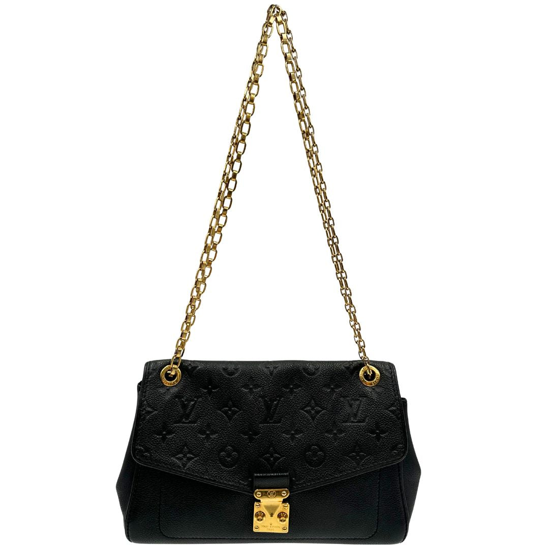 Front di una borsa Louis Vuitton in pelle nera monogram Empreinte con parti metalliche dorate; munita di una tracolla scorrevole in catena. Indossabile a spalla e a tracolla.