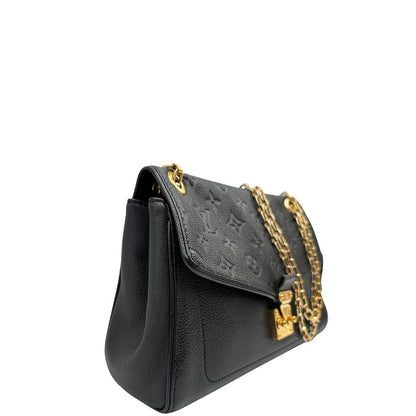 Laterale sinistro di una borsa Louis Vuitton in pelle nera monogram Empreinte con parti metalliche dorate; munita di una tracolla scorrevole in catena. Indossabile a spalla e a tracolla.