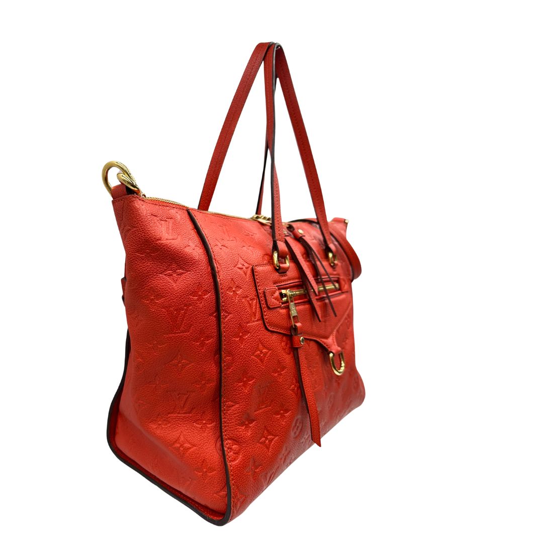lato Borsa Louis Vuitton pelle color rosso aranciato monogram Empreinte con parti metalliche dorate; munita di doppi manici e una tracolla amovibile e regolabile. Completa di lucchetto e chiavi, di lusso, originale, ottime condizioni. 