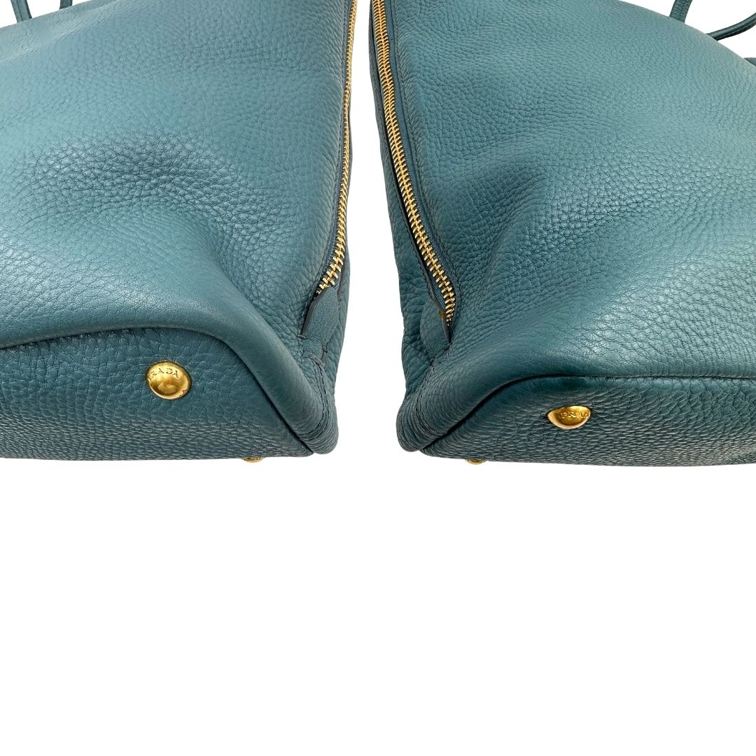 angoli Borsa Tote Prada in pelle martellata color teal con parti metalliche dorate; munita di doppi manici, indossabile a spalla. Completa di dustbag, di lusso, originale, usata. 