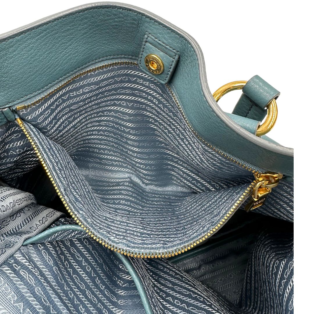 interno Borsa Tote Prada in pelle martellata color teal con parti metalliche dorate; munita di doppi manici, indossabile a spalla. Completa di dustbag, di lusso, originale, usata. 