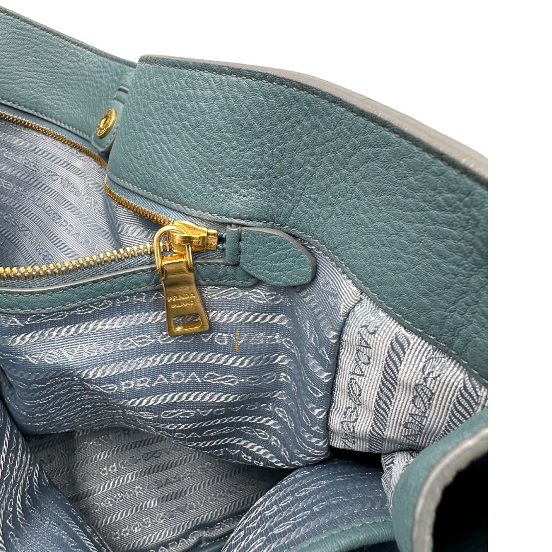 interno Borsa Tote Prada in pelle martellata color teal con parti metalliche dorate; munita di doppi manici, indossabile a spalla. Completa di dustbag, di lusso, originale, usata. 