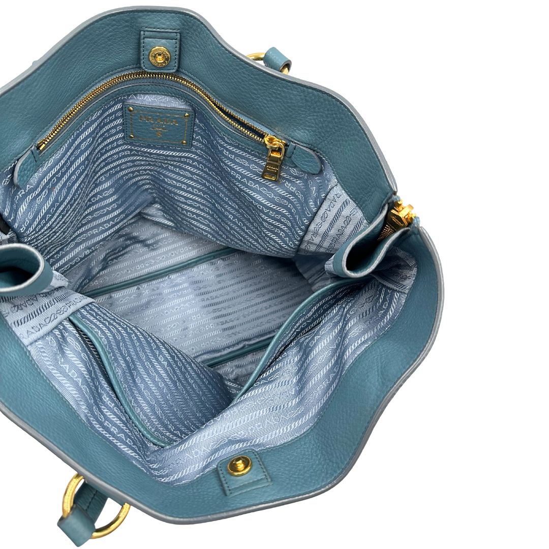 interno Borsa Tote Prada in pelle martellata color teal con parti metalliche dorate; munita di doppi manici, indossabile a spalla. Completa di dustbag, di lusso, originale, usata. 