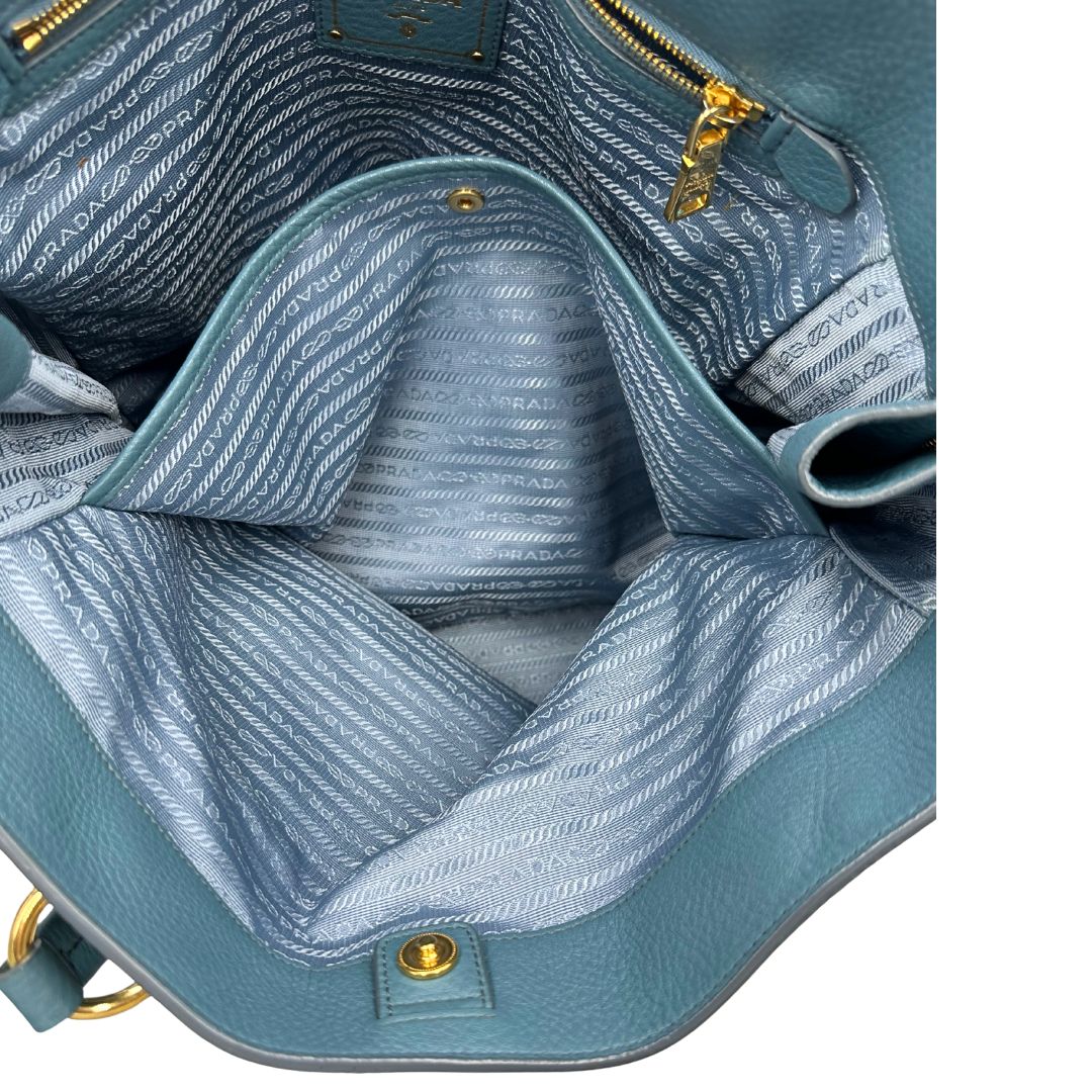 interno Borsa Tote Prada in pelle martellata color teal con parti metalliche dorate; munita di doppi manici, indossabile a spalla. Completa di dustbag, di lusso, originale, usata. 