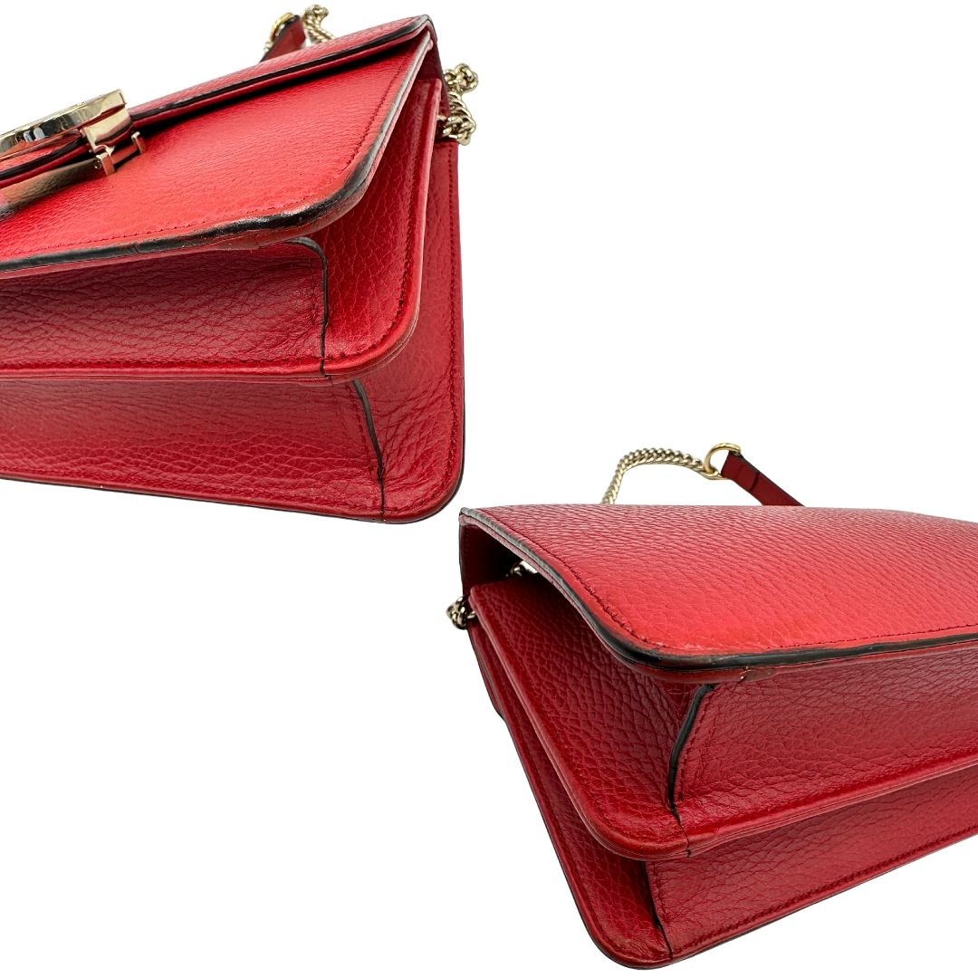 Angoli di una borsa Gucci Interlocking in pelle martellata rossa con parti metalliche dorate. Munita di una tracolla scorrevole in catena non amovibile e spallaccio in pelle. Chiusura con doppie G incrociate. Completa di dustbag. Indossabile a spalla o a tracolla.