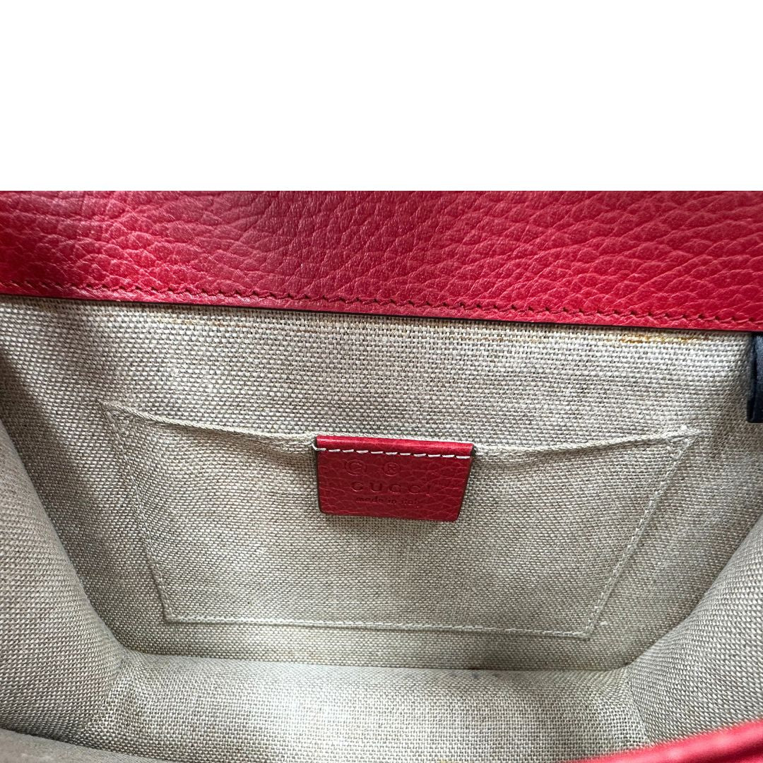 Interno di una borsa Gucci Interlocking in pelle martellata rossa con parti metalliche dorate. Munita di una tracolla scorrevole in catena non amovibile e spallaccio in pelle. Chiusura con doppie G incrociate. Completa di dustbag. Indossabile a spalla o a tracolla.