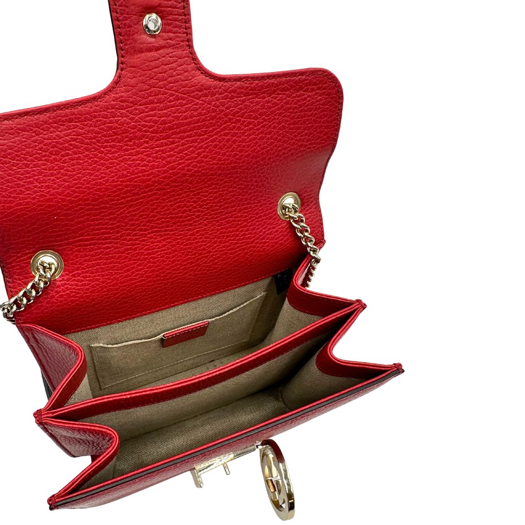 Interno di una borsa Gucci Interlocking in pelle martellata rossa con parti metalliche dorate. Munita di una tracolla scorrevole in catena non amovibile e spallaccio in pelle. Chiusura con doppie G incrociate. Completa di dustbag. Indossabile a spalla o a tracolla.