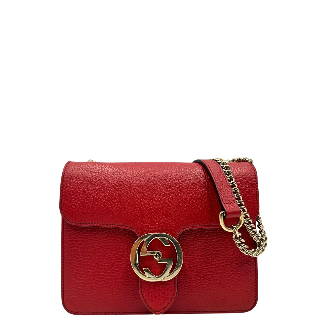 Front di una borsa Gucci Interlocking in pelle martellata rossa con parti metalliche dorate. Munita di una tracolla scorrevole in catena non amovibile e spallaccio in pelle. Chiusura con doppie G incrociate. Completa di dustbag. Indossabile a spalla o a tracolla.