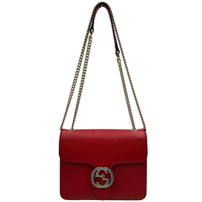 Front di una borsa Gucci Interlocking in pelle martellata rossa con parti metalliche dorate. Munita di una tracolla scorrevole in catena non amovibile e spallaccio in pelle. Chiusura con doppie G incrociate. Completa di dustbag. Indossabile a spalla o a tracolla.