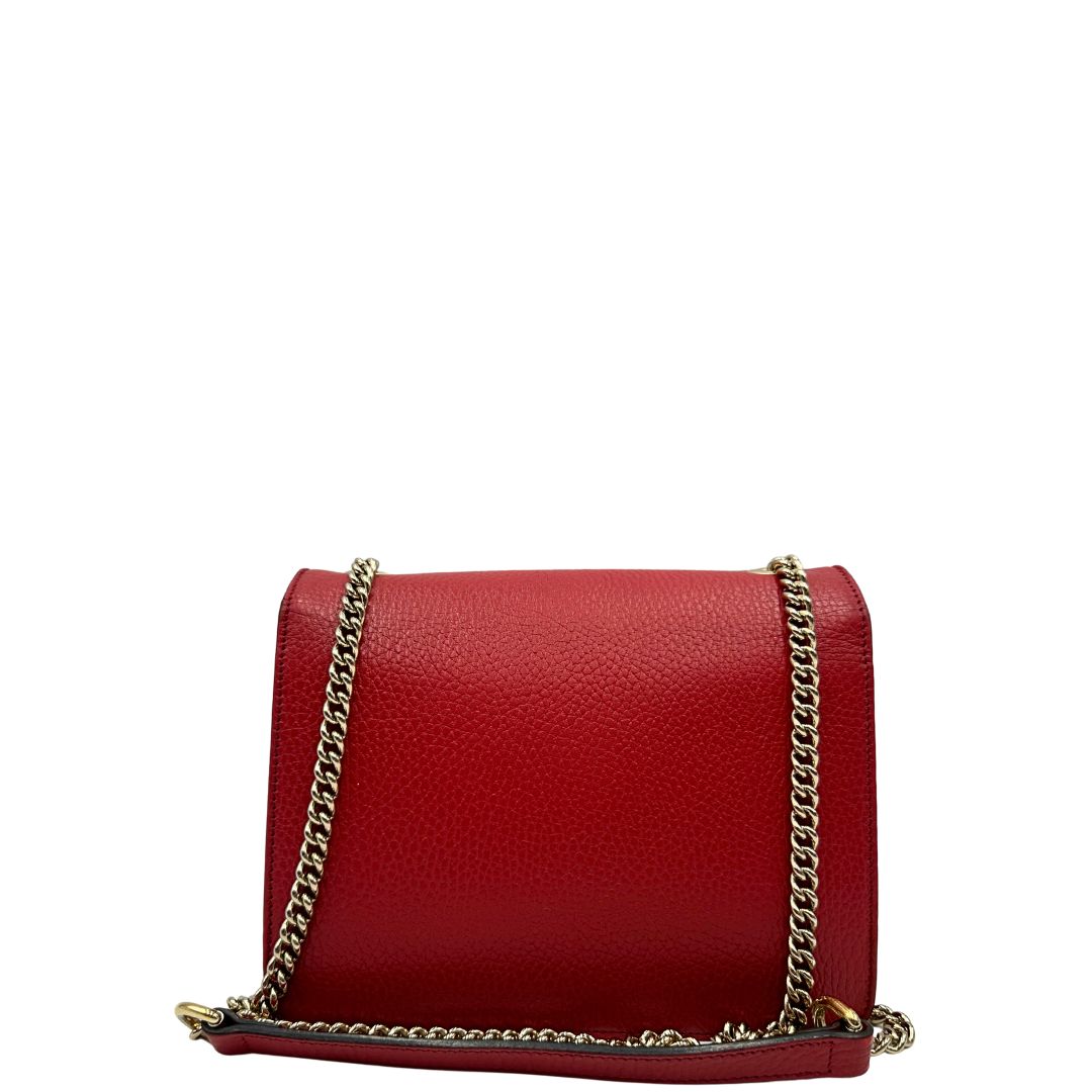 Retro di una borsa Gucci Interlocking in pelle martellata rossa con parti metalliche dorate. Munita di una tracolla scorrevole in catena non amovibile e spallaccio in pelle. Chiusura con doppie G incrociate. Completa di dustbag. Indossabile a spalla o a tracolla.