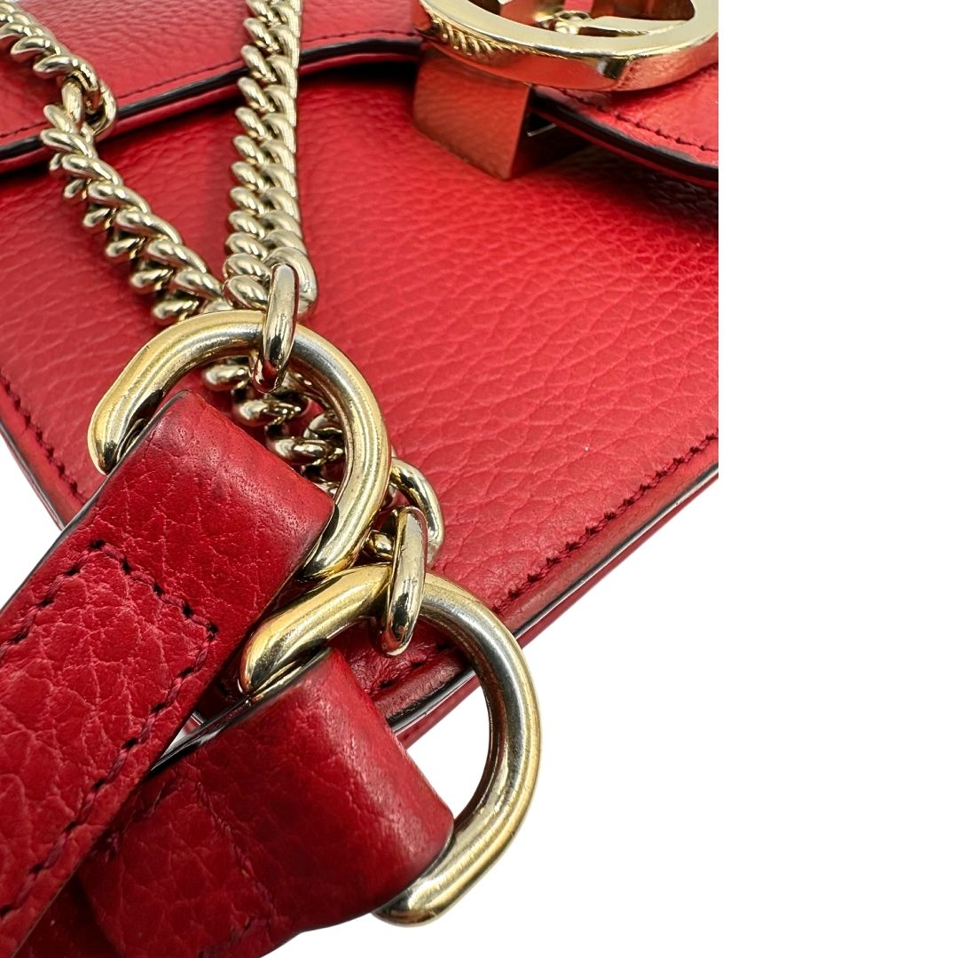 Parti metalliche di una borsa Gucci Interlocking in pelle martellata rossa con parti metalliche dorate. Munita di una tracolla scorrevole in catena non amovibile e spallaccio in pelle. Chiusura con doppie G incrociate. Completa di dustbag. Indossabile a spalla o a tracolla.