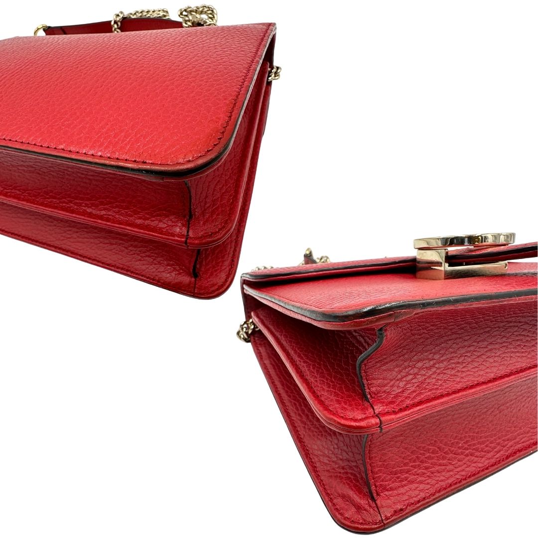 Angoli di una borsa Gucci Interlocking in pelle martellata rossa con parti metalliche dorate. Munita di una tracolla scorrevole in catena non amovibile e spallaccio in pelle. Chiusura con doppie G incrociate. Completa di dustbag. Indossabile a spalla o a tracolla.