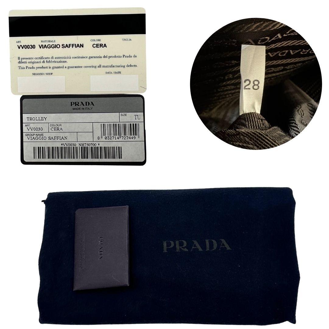 Dustbag e card di una valigia Prada in pelle saffiano bianco latte e finiture nere, con dettagli metallici argentati. L’interno è foderato in tessuto jacquard con motivo logo Prada, dotato di cinghie regolabili per fissare il contenuto e tasca con zip. Dispone di doppia chiusura con cerniera e lucchetto numerico in metallo argentato, manico superiore e laterale in pelle, maniglia estraibile e ruote posteriori per facilitarne il trasporto. Completa di dustbag, clochette porta address e card d'autenticità.