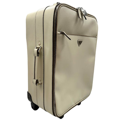 Laterale sinistro di una valigia Prada in pelle saffiano bianco latte e finiture nere, con dettagli metallici argentati. L’interno è foderato in tessuto jacquard con motivo logo Prada, dotato di cinghie regolabili per fissare il contenuto e tasca con zip. Dispone di doppia chiusura con cerniera e lucchetto numerico in metallo argentato, manico superiore e laterale in pelle, maniglia estraibile e ruote posteriori per facilitarne il trasporto. Completa di dustbag, clochette porta address e card d'autenticità.