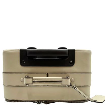 Vista superiore di una valigia Prada in pelle saffiano bianco latte e finiture nere, con dettagli metallici argentati. L’interno è foderato in tessuto jacquard con motivo logo Prada, dotato di cinghie regolabili per fissare il contenuto e tasca con zip. Dispone di doppia chiusura con cerniera e lucchetto numerico in metallo argentato, manico superiore e laterale in pelle, maniglia estraibile e ruote posteriori per facilitarne il trasporto. Completa di dustbag, clochette porta address e card d'autenticità.