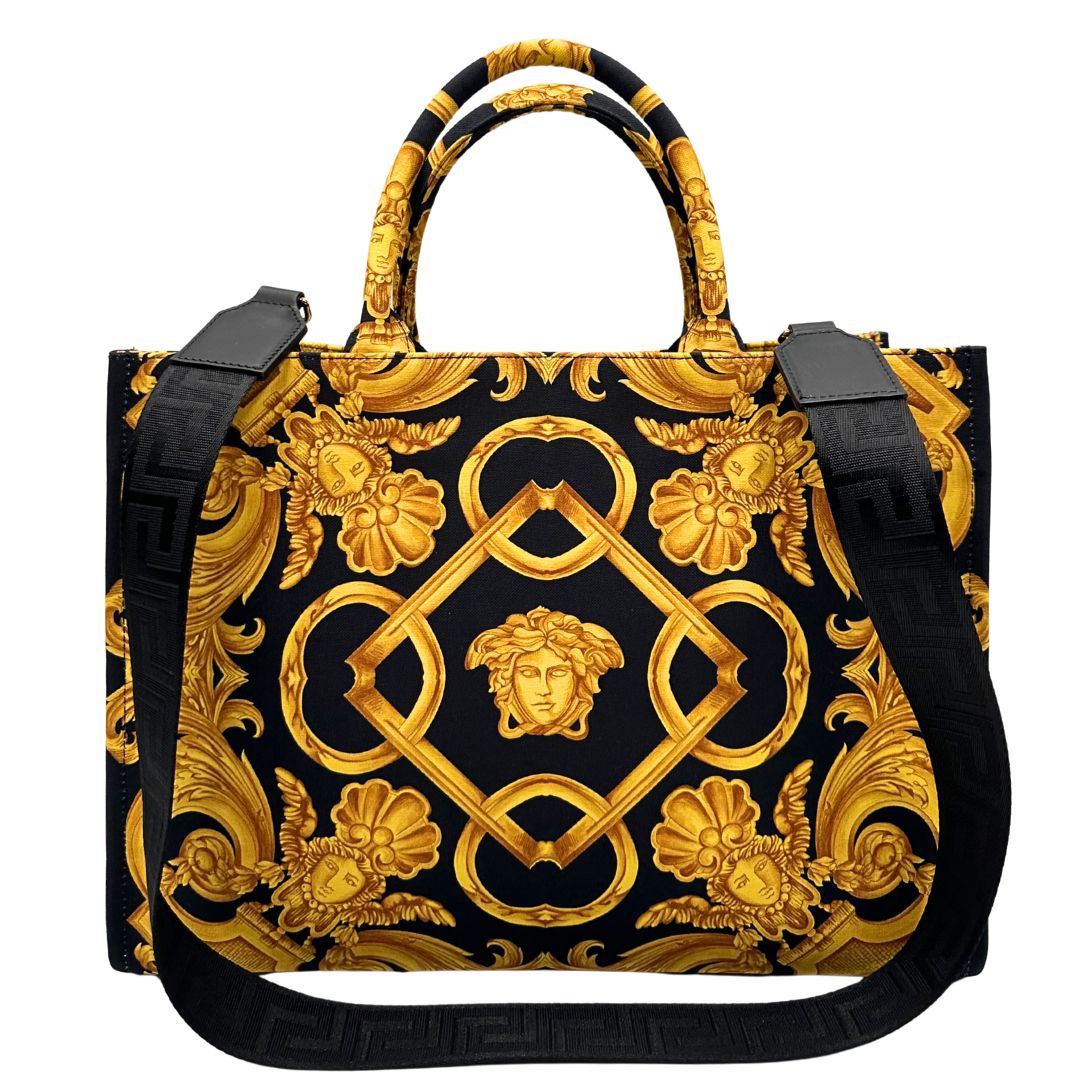 Retro di una borsa Versace in tela com motivo jacquard barocco in nero e giallo tipico della Maison. Presenta doppi manici stondati e una tracolla amovibile in tessuto motivo greca, con dettagli in pelle neri. Completa di dustbag.