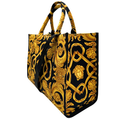 Laterale destro di una borsa Versace in tela com motivo jacquard barocco in nero e giallo tipico della Maison. Presenta doppi manici stondati e una tracolla amovibile in tessuto motivo greca, con dettagli in pelle neri. Completa di dustbag.