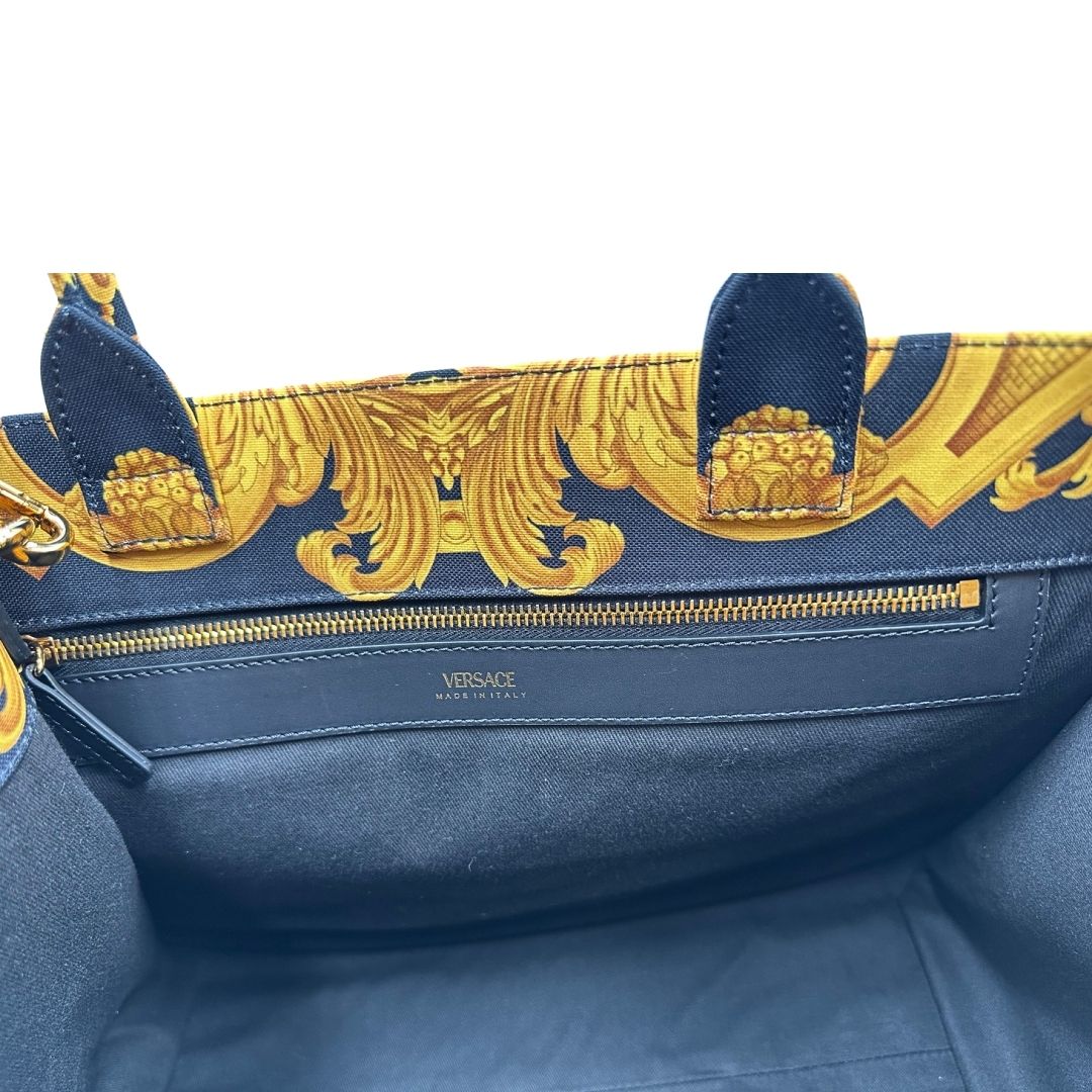 Interno di una borsa Versace in tela com motivo jacquard barocco in nero e giallo tipico della Maison. Presenta doppi manici stondati e una tracolla amovibile in tessuto motivo greca, con dettagli in pelle neri. Completa di dustbag.