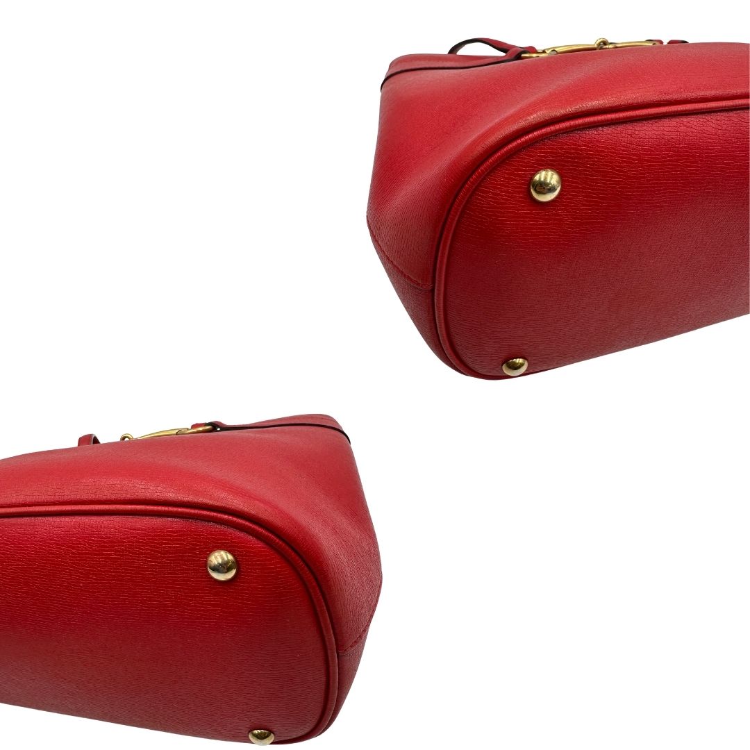 angoli Borsa Gucci in pelle rossa con parti metalliche dorate; munita di doppi manici e impreziosita da dettaglio Horsebit sul front. Completa di dustbag, di lusso, originale.  