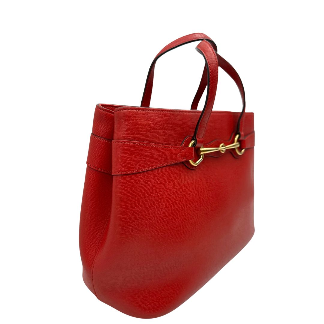 lato Borsa Gucci in pelle rossa con parti metalliche dorate; munita di doppi manici e impreziosita da dettaglio Horsebit sul front. Completa di dustbag, di lusso, originale. 