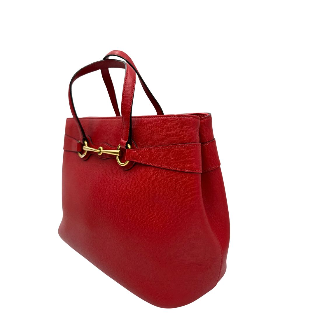 lato Borsa Gucci in pelle rossa con parti metalliche dorate; munita di doppi manici e impreziosita da dettaglio Horsebit sul front. Completa di dustbag, di lusso, originale. 